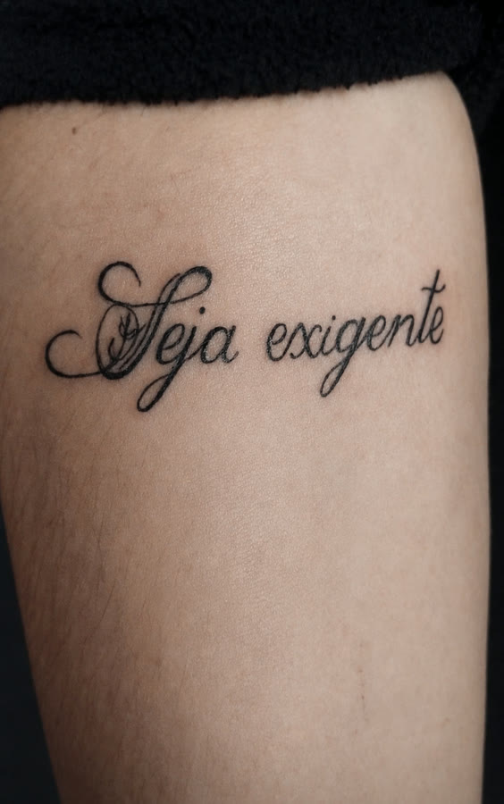 'Seja exigente' em caligrafia ornamentada na perna