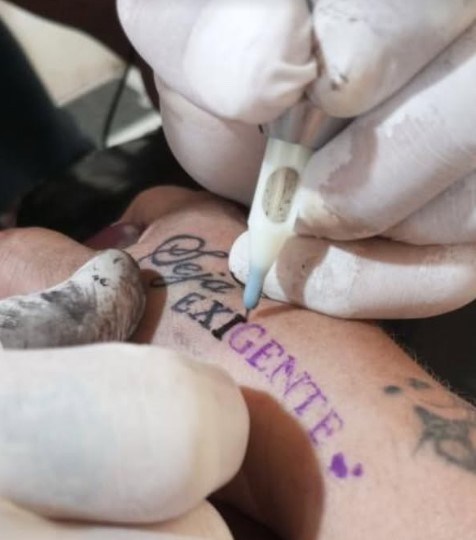 A agulha em ação: 'Seja Exigente' sendo tatuado ao vivo na pele